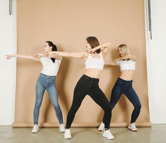 Person performing a dynamic stretching exercise in a bright studio.